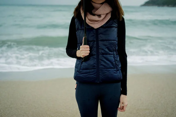 Крупним планом жінка стоїть з парасолькою перед морем взимку — стокове фото