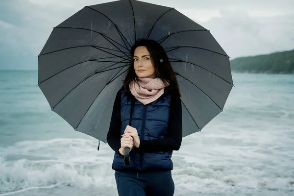 Πορτρέτο της νεαρής γυναίκας που στέκεται με ομπρέλα στην θάλασσα μπροστά μου — Φωτογραφία Αρχείου