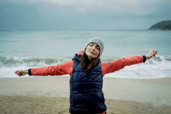 Jovem vestindo um colete esportivo exercitando-se no mar de inverno — Fotografia de Stock