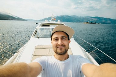 Genç adam bir kap içinde selfie karşı bir yat yaz aylarında yapar