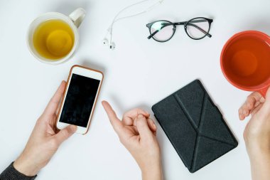 Pnone beyaz tablo, üstten görünüm ile çay bardak iki el ele tutuşur