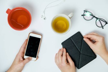 Pnone beyaz tablo, üstten görünüm ile çay bardak iki el ele tutuşur