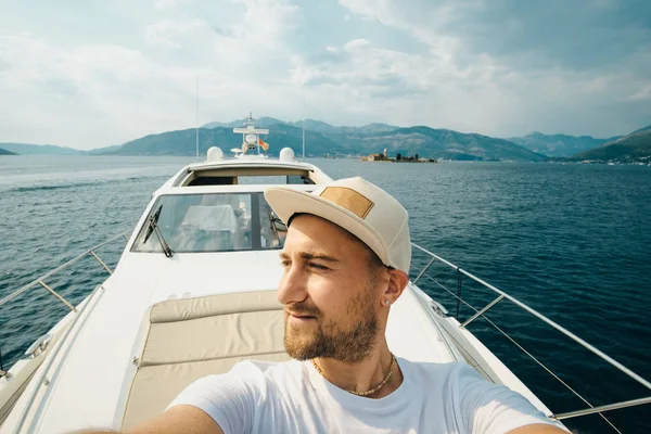 Giovane con un cappello fa selfie contro uno yacht in estate — Foto Stock