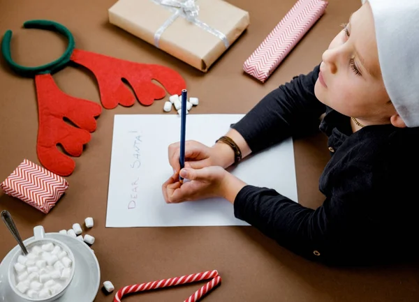 Brief voor Santa. Jongen handen op papier, geschenken en marshmallows — Stockfoto