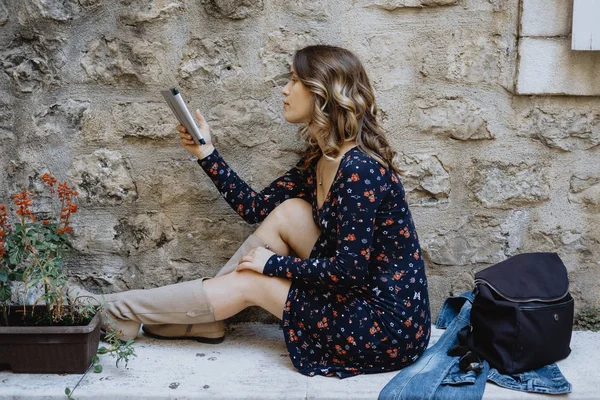 Genç neşeli kadın bir e-kitap açık okuma