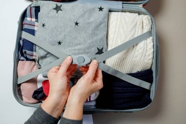 Bavul içinde paketlenmiş elbise eller kadın. Kış tatilleri ve hol