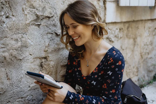 Primeros planos Joven mujer alegre leyendo un libro electrónico al aire libre — Foto de Stock
