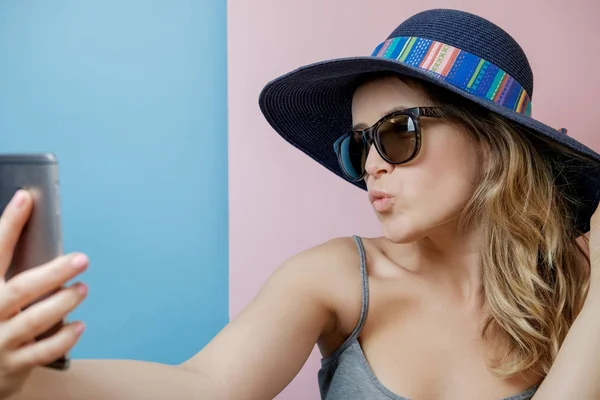 Young woman in hat and sunglasses with phone — Stock Photo, Image