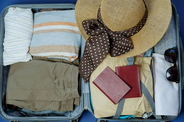 Open suitcase packed for travelling. Summer vacations. Top view — Stock Photo, Image