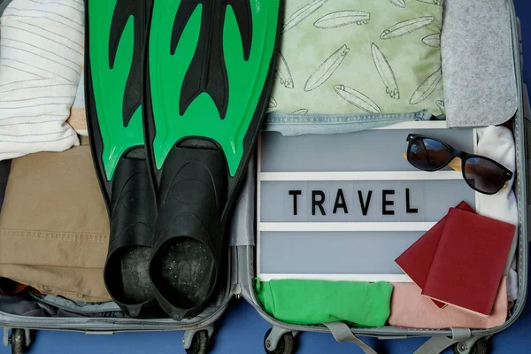 Відкрита валіза упакована для подорожей. Літні канікули. Вид зверху — стокове фото