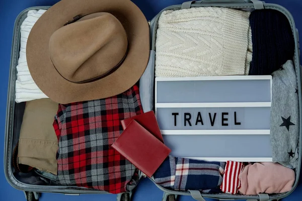 Travel board in Open suitcase packed with clothes. Summer vacati — Stock Photo, Image