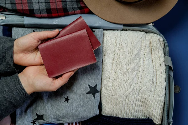 Woman hands with passports on the background Open suitcase packe — Stock Photo, Image