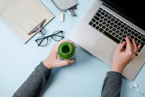 Mains de femme avec ordinateur portable et smoothies verts avec pomme sur t bleu — Photo