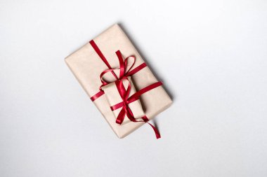 Hediye kutusu beyaz zemin üzerine kırmızı kurdele ile. Üstten Görünüm, düz