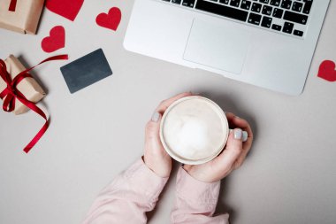 Kredi kartı ve dizüstü bilgisayar, kalpli hediye kutusu ile kadın el ve