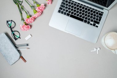 Düz yatıyordu kadın Ofis Masası. Dizüstü bilgisayar, pembe carnatio ile çalışma alanı