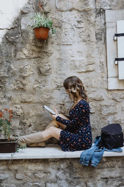 Jovem loira encaracolado bela mulher lendo um e-book em o — Fotografia de Stock