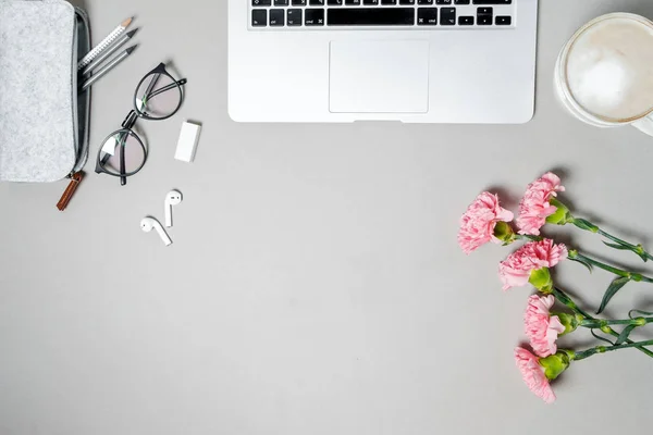 Mesa de escritório de mulher leiga plana. Espaço de trabalho com laptop, carnatio rosa — Fotografia de Stock