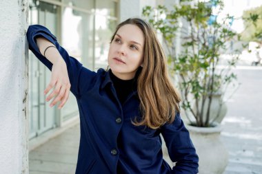 Açık havada yürüyüş bahar şık mavi paltolu Trendy genç gülümseyen kadın portresi