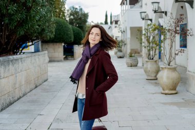 Açık havada yürüyüş bahar şık bordo paltolu trendy genç kadın. 