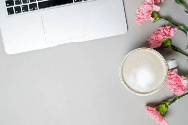 Düz yatıyordu kadın Ofis Masası. Laptop, pembe karanfil, beyaz masa üzerinde ileti örneği ile çalışma alanı. Top vie