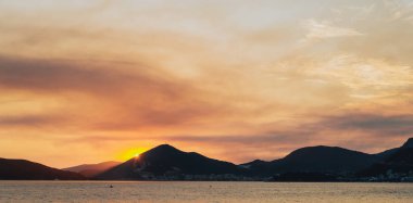 Dağlar siluetleri, Montenegr ile denizde turuncu günbatımı