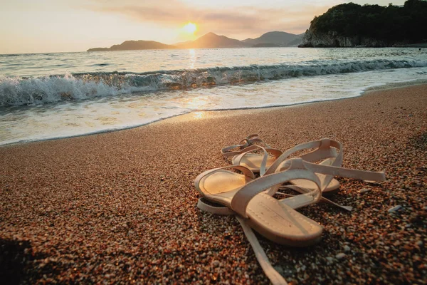 Sandalen Sand Vor Dem Hintergrund Der Untergehenden Sonne Damenschuhe Strand — Stockfoto