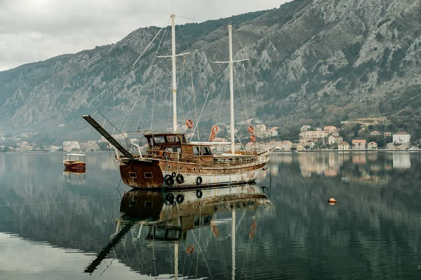 Ancient ship in Adriatic Sea gulf with mountains in Montenegro, Kotor