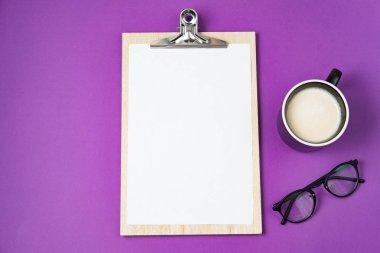 Beyaz boş boş ve bir fincan kahve mor bir arka plan üzerinde. Üstten Görünüm, düz yatıyordu