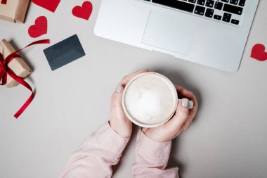 Kredi kartı ve laptop, kalp ve beyaz arka plan üzerinde kahve hediye kutusu ile kadın el. Sevgililer günü, online alışveriş kavramı, tatil arka plan. Üstten Görünüm