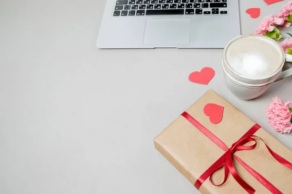 Laptop, gift box with heart and coffee on white background. Valentine day, online shopping concept, holiday background. Top view