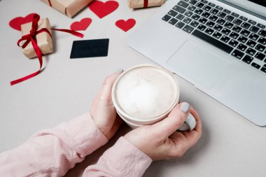 Kredi kartı ve dizüstü bilgisayar, kalpli hediye kutusu ile kadın el ve