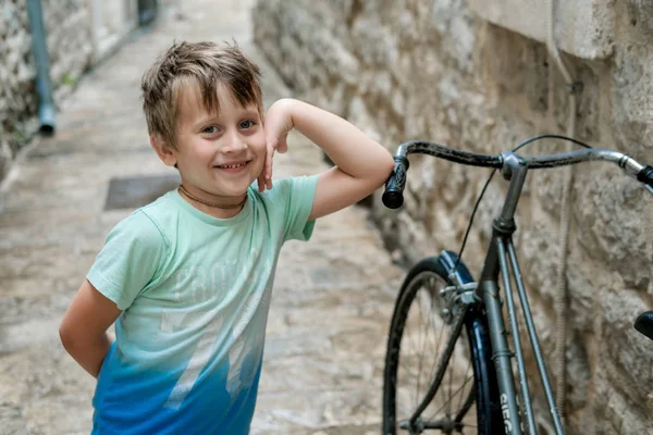 Roztomilý chlapec v zeleném tričku proti staré město — Stock fotografie