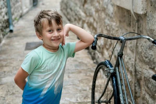 Carino ragazzo in un verde t-shirt contro vecchio città — Foto Stock