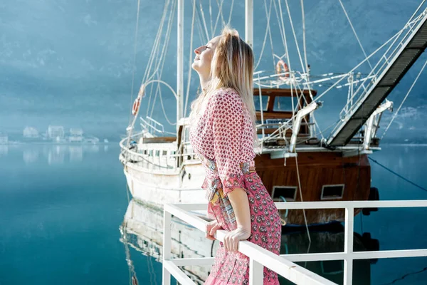 Молода блондинка в рожевих окулярах і плаття біля моря на су — стокове фото