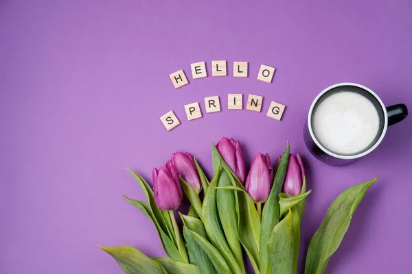 Tasse de café et tulipes violettes sur fond violet et boisé — Photo