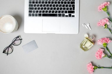 Düz yatıyordu kadın Ofis Masası. Dizüstü bilgisayar, pembe carnatio ile çalışma alanı