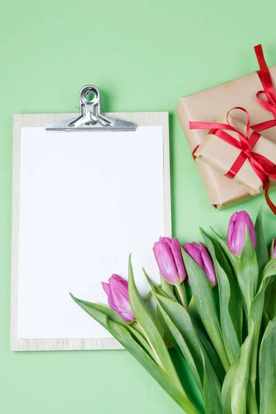 Branco vazio em branco, tulipas roxas e uma xícara de café em um verde — Fotografia de Stock