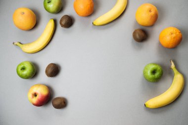Renkli taze meyve üzerinde gri tablosudur. Portakal, muz, elma, kivi
