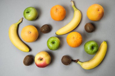 Renkli taze meyve üzerinde gri tablosudur. Portakal, muz, elma, kivi