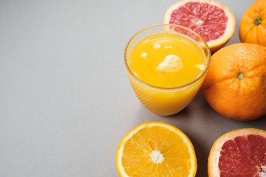 Narenciye dilimlerini portakal ve greyfurt suyu üzerinde gri backgrou
