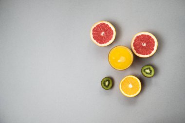 Narenciye dilimlerini portakal ve greyfurt suyu üzerinde gri backgrou