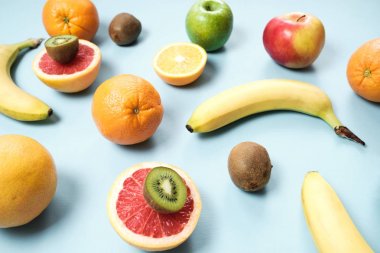 Renkli taze meyve üzerinde gri tablosudur. Portakal, muz, elma, kivi