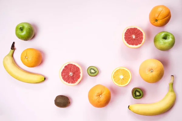 Colorida fruta fresca en la mesa Gray. Naranja, plátano, manzanas, kiwi — Foto de Stock