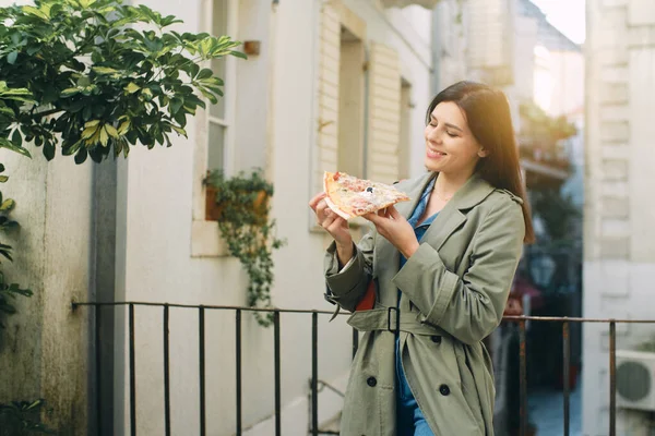 Hermosa Joven Morena Sonriente Una Gabardina Verde Come Pizza Vieja — Foto de Stock