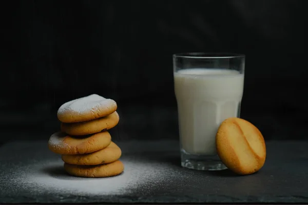 Stapelweise Kekse Mit Puderzucker Und Einem Glas Milch Auf Schwarzem — Stockfoto