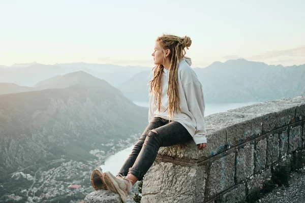 Glimlachende Reiziger Vrouw Met Dreadlocks Zitten Top Van Berg Kijken — Stockfoto