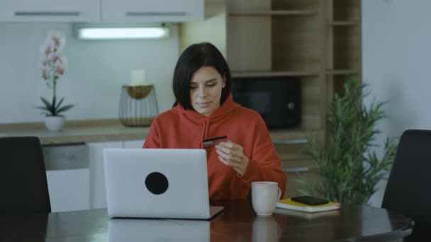 Konzentrierte Junge Brünette Frau Rotem Pullover Mit Kreditkarte Die Hause — Stockvideo