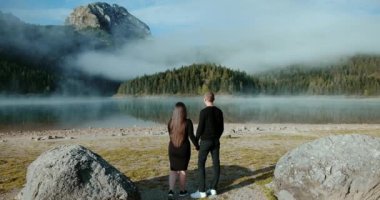 Vahşi doğadaki mutlu aşıklar, Karadağ 'daki Güz Kara Gölü' ne bakan genç bir çift. Ulusal Park Durmitor 