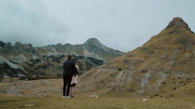 Vahşi doğadaki mutlu aşığın arka planı, Karadağ 'daki Durmitor Ulusal Parkı' na bakan genç çift
